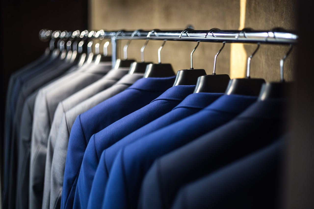 Close-up of neatly arranged suits in a wardrobe, showcasing fashion and organization.